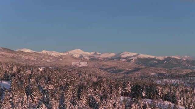 Mount Blue Sky spring pink morning sunrise alpenglow Conifer Evergreen Colorado aerial drone Denver Front Range Rocky Mountains Mt Evans landscape snowy forest trees valley rolling hills forward