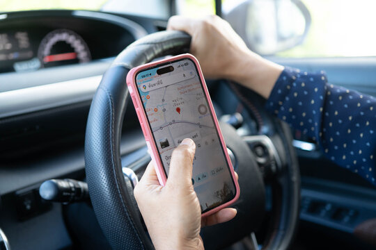 Bangkok, Thailand March 15, 2024 Woman looking at navigation map on her phone while driving car.
