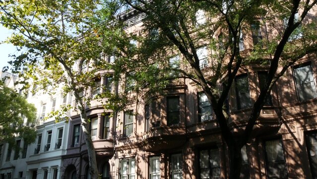 New York City townhouse buildings, brownstone row houses in Manhattan or Brooklyn, United States of America. Classic buildings on residential district street. Real estate property. Rowhouse townhome