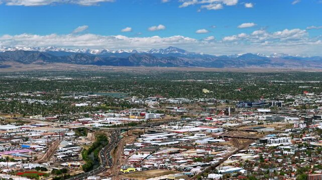 Downtown Denver springtime sunny morning vibrant blue sky Burnham Yard railyard Denver Broncos stadium cityscape aerial drone Colorado i25 cars traffic city buildings Front Range rockies circle left