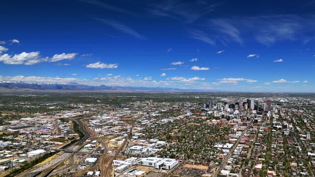 Downtown Denver landscape spring summer sunny morning vibrant blue sky Burnham Yard railyard Denver Broncos stadium aerial drone Colorado i25 cars traffic city buildings Front Range rockies forward