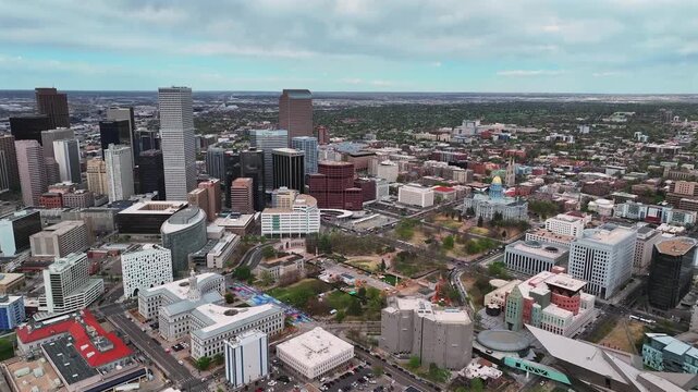 Civic Center Park Capitol Hill Liberty Park skyscraper office buildings Downtown Lodo city of Denver Colorado aerial drone Capitol buildings cityscape spring cloudy blue sky cars forward pan up motion