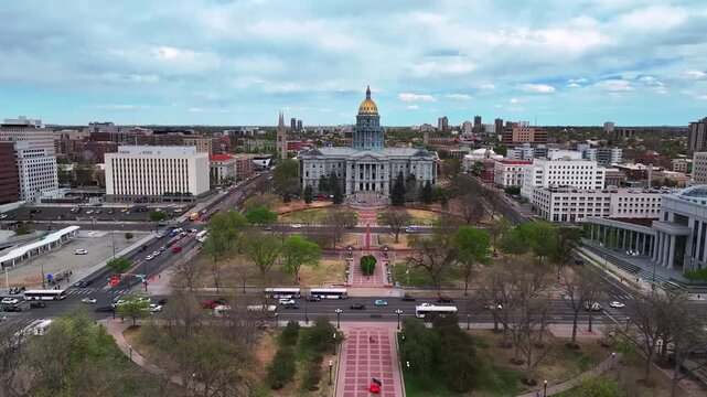 City of Denver Civic Center Park event center downtown Lodo Capitol Hill Colorado Capitol buildings aerial drone cityscape spring cloudy blue sky afternoon two lane way cars traffic forward motion