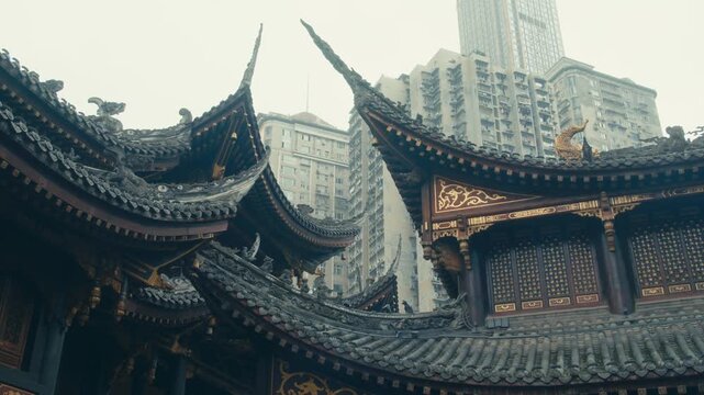 Chongqing Luohan Temple Intricate Dragon Carved Roof Tips and Golden Wood Details with Residential Towers in Haze