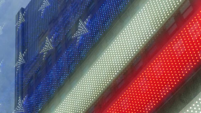 American flag on Broadway, Times Square in New York City, United States. Electric lights glowing. Symbol of democracy, national attribute of USA. 4th July or 911 September 11 concept. Military Island