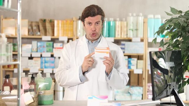 In sales area of pharmacy, man consultant sells intestinal probiotic. Healthcare worker advertises safe remedy for symptom relief
