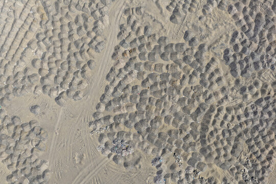 Aerial view of desert terrain with waste rock piles in DME dump