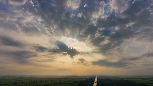 Cinematic sunbeams breaking through dramatic clouds over Mekong Delta at dawn