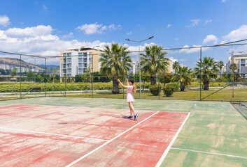 Fototapeta premium Woman playing tennis on outdoor court. Concept of fitness, recreation, active lifestyle, sport and wellbeing
