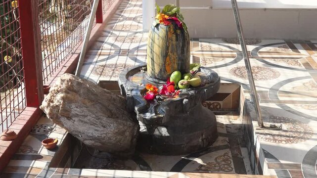 Raw video footage of sacred water dropping on Shivling inside a Hindu temple in Uttarakhand India showcasing spirituality prayer rituals and religious worship.