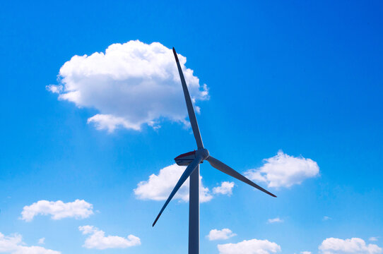 青空と白い雲に映える風力発電機と再生可能エネルギー
