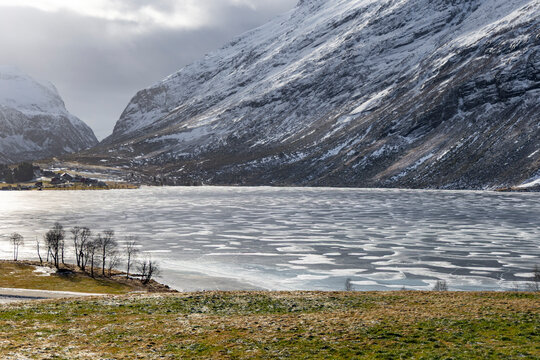 A beautiful cloudy day during an early spring at a frozen mountain lake. A winter scenery on Eidsvatnet in Norway, Geiranger area, UNESCO world heritage site.