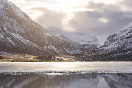 A beautiful cloudy day during an early spring at a frozen mountain lake. A winter scenery on Eidsvatnet in Norway, Geiranger area, UNESCO world heritage site.