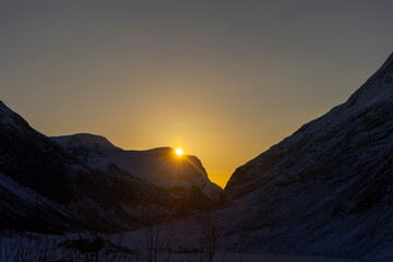 Naklejka premium A beautiful winter morning landscape with golden sunrise light near Eidsdal. A winter scenery on Eidsvatnet in Norway, Geiranger area, UNESCO world heritage site.