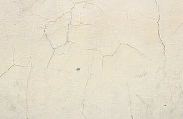 Fototapeta premium Natural cream cracked wall texture background with vintage rough cement plaster cracks for rustic retro design asset