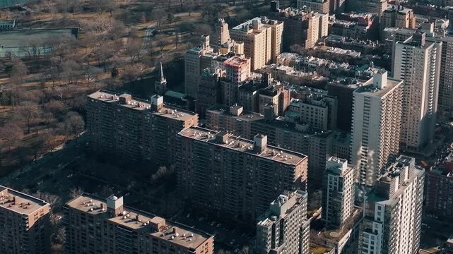 Cinematic aerial view of upper east side skyline buildings and park landscape in New York City.