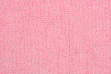 A detailed close up of a soft pink microfiber fabric texture with dense synthetic loops © nahhan
