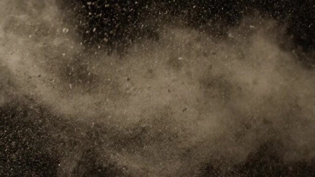 Brown powder explodes in a dark room with particles flying everywhere freely
