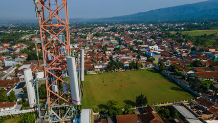 Aerial View of Cellular Telecommunications Tower Near Football Field in Urban Area © katakaneh