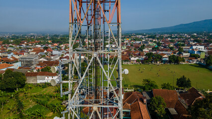 Aerial View of Cellular Telecommunications Tower Near Football Field in Urban Area © katakaneh