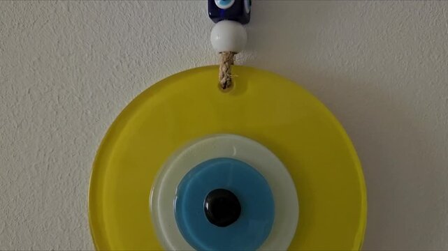 Glass evil eye wall hanging art. Traditional blue eye nazar amulet inside a yellow circle for home decor and protection aesthetic.