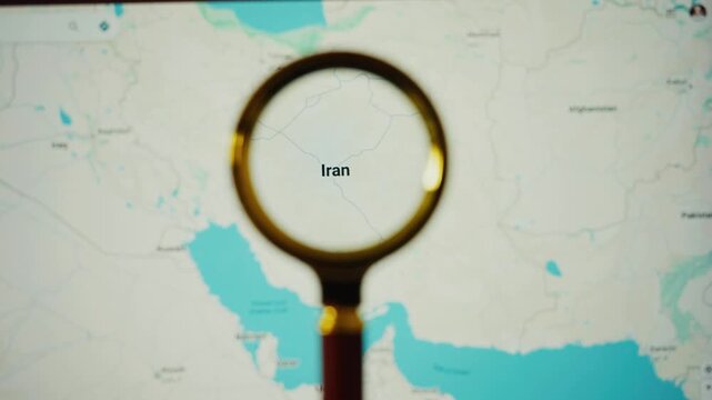 Magnifying glass focusing on iran on digital world map