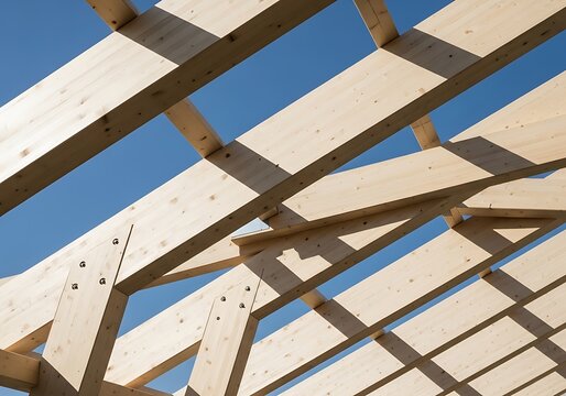 Modern wooden roof structure with glulam beams against clear blue sky