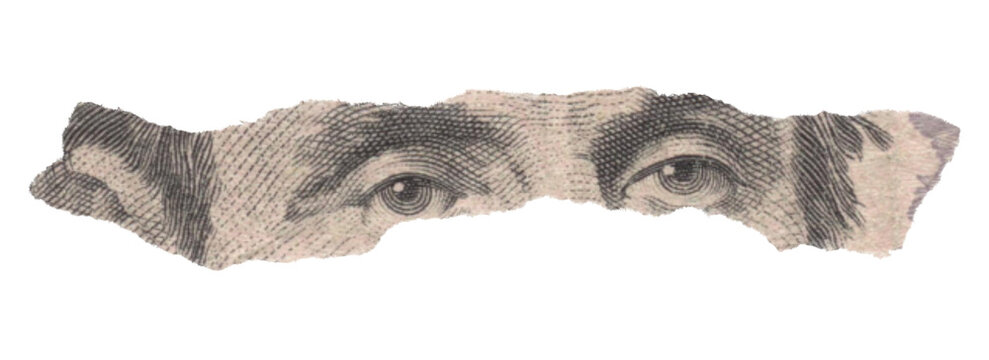 Close-up of Abraham Lincoln Eyes on a Torn Five Dollar Bill
