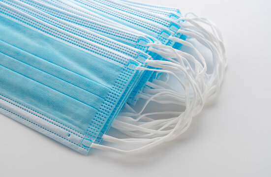 Close Up of Stacked Blue Disposable Surgical Face Masks with White Ear Loops