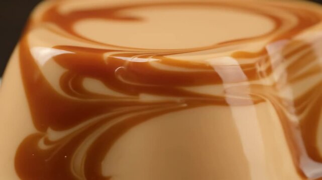 Macro shot of decadent caramel swirl dessert. extreme close-up of glossy panna cotta or cr&egrave;me caramel texture with rich syrup topping.