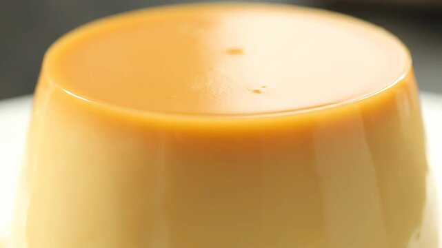 Close-up macro shot of delicious golden cr&egrave;me caramel or flan pudding dessert with glossy caramel glaze on top.