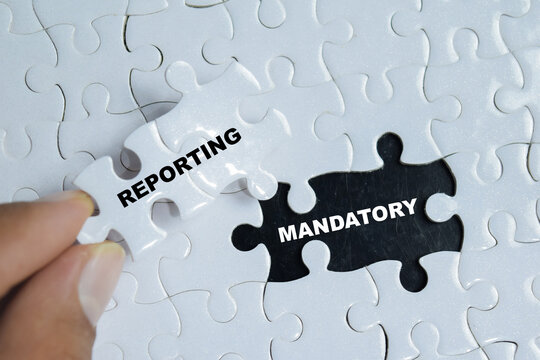 Piece of jigsaw puzzle with word mandatory reporting. For corporate compliance, transparency and legal requirements.