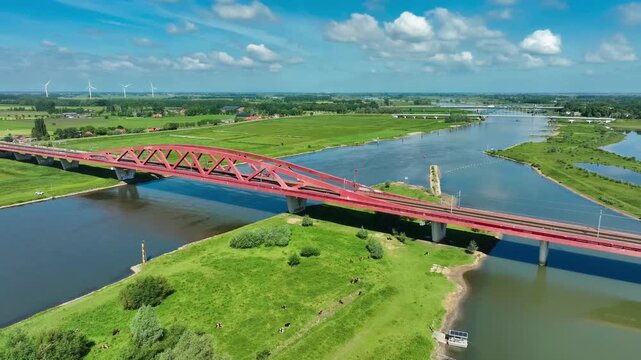 Aerial footage of the Hanzeboog (Hanseatic Arch), a combined railway and cycle bridge spanning the IJssel river. The bridge was opened in June 2011