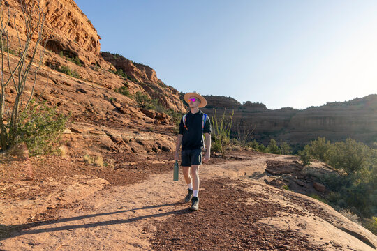 Young adult explores a red rock desert trail