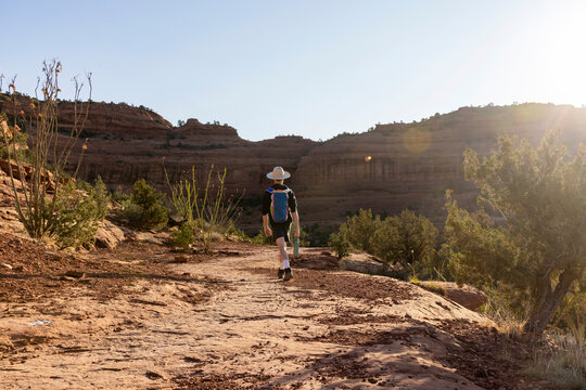 Man hiking on a desert trail in a red rock canyon
