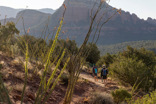 Two distant people hiking on a trail in the desert mountains
