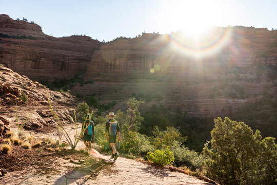 Two hikers exploring a sunny desert canyon trail