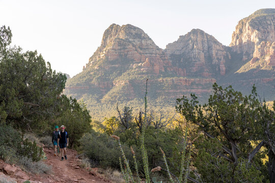 Two distant young men hiking on a sunny desert trail