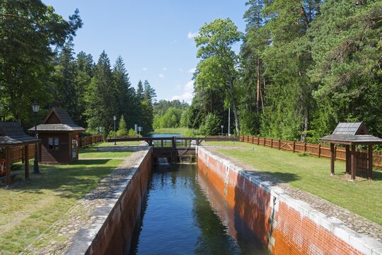 Canalised watercourse through the forest with lock and wooden railings in summer, Śluza Perkuć, Perkuc lock, Kanał Augustowski, August&oacute;w Canal, Augustow, canal, Płaska, Plaska, Powiat Augustowski, Podlaskie Voivodeship, Poland