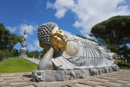 Monumental reclining Buddha statue in a green and peaceful park under a clear blue sky, Bacalh&ocirc;a, Bacalhoa Buddha Eden, Quinta dos Loridos, largest oriental garden in Europe, Bombarral, Oeste, Centro, Portugal