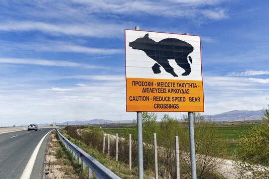 Bilingual warning sign on motorway, caution, drive slowly, bears crossing the road, Western Macedonia, Greece