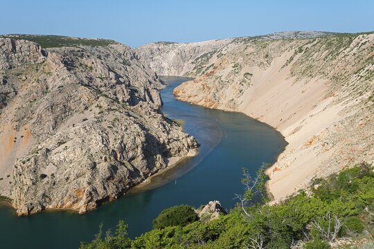 A deep river meanders through rocky cliffs under a clear sky, Pariževacka Glavica, Parizevacka, location of Karl May films, Zrmanja River, Jasenice, Zadar County, Croatia