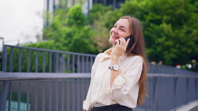 Caucasian businesswoman talking on phone outdoors on rooftop garden. 