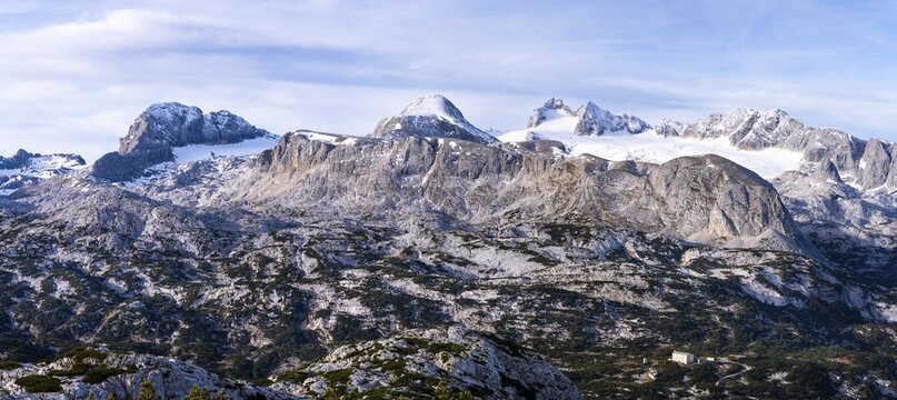 Panorama of the Dachstein mountains in autumn with some snow. From the left: Koppenkarstein, Schladminger Glacier, Hoher Gjaidstein, Hoher Dachstein, Niederer Dachstein, Steiner Scharte, Hallst&auml;tter Glacier, Taubenkogel, Hohes Kreuz. Blue sky with clouds. Dachstein massif, Upper Austria, Austria