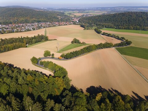 Drone shot, curve in autumnal forest, Roter Berg, L485, between Diekholzen and Sibbesse, in the background Diekholzen, district of Hildesheim, Lower Saxony, Germany