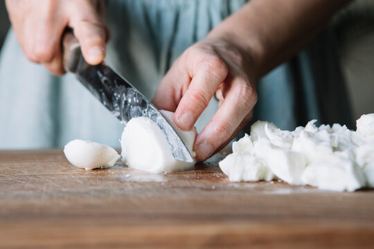 Close-up of woman cutting mozzarella