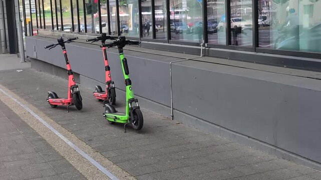 Free electric scooters available on city street near shops and cafes during daytime