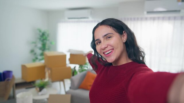 POV of Hispanic woman using phone video call while moving into new home. 