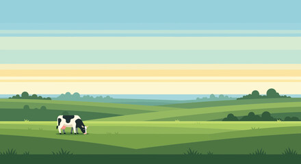 Fototapeta premium Peaceful pastoral landscape with a black and white cow grazing in a lush green field at sunrise.