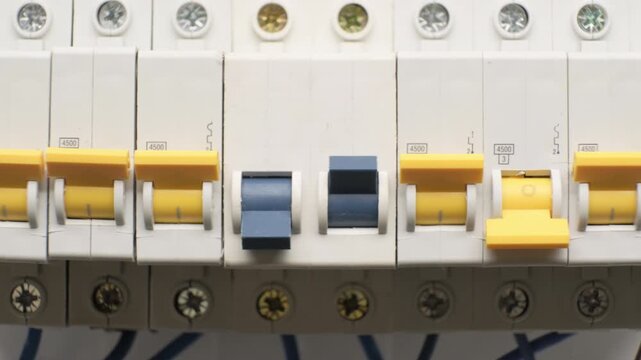 Row of protection modular circuit breakers in electrical panel box close-up, equipment for power supply systems in domestic and commercial power grids
